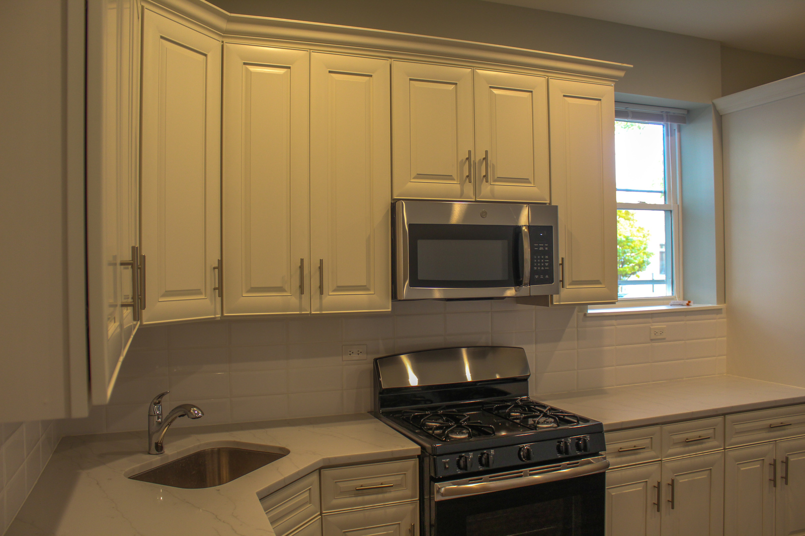 1701 West Nelson Street, Unit 1F Chicago, IL 60657 - Photo 9 of 10 a kitchen with granite countertop a sink and a stove top oven