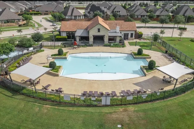 an aerial view of a house with swimming pool and outdoor seating