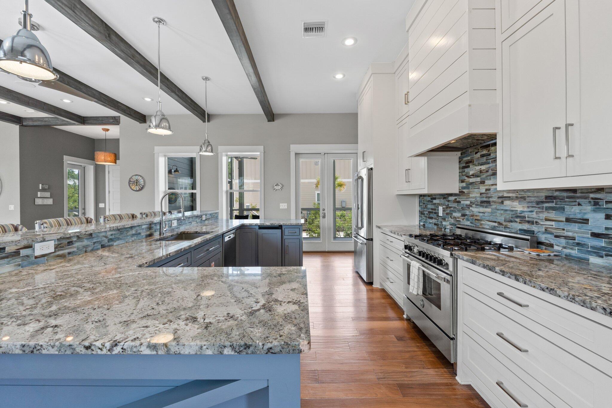 104 Pinwheel Court Port St. Joe, FL 32456 - Photo 22 of 119 a large kitchen with stainless steel appliances granite countertop a lot of counter space and wooden floors
