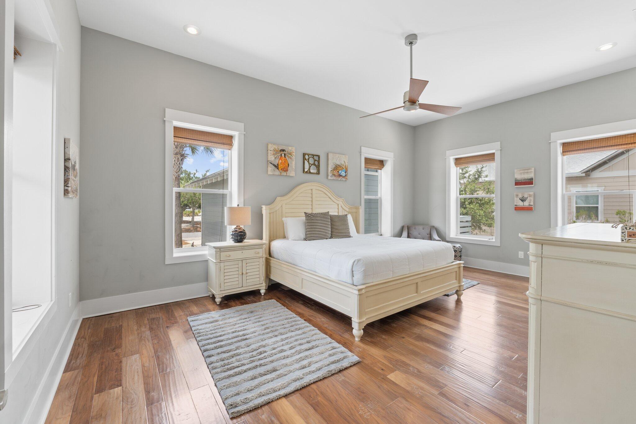 104 Pinwheel Court Port St. Joe, FL 32456 - Photo 59 of 119 a bedroom with a large bed a chandelier and windows