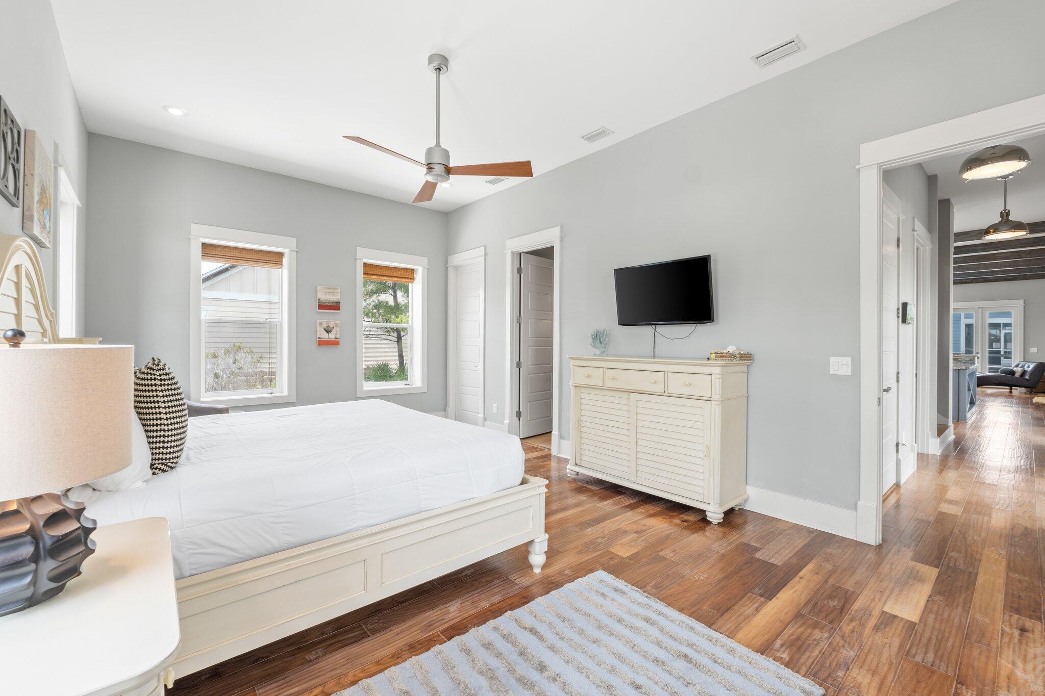 104 Pinwheel Court Port St. Joe, FL 32456 - Photo 60 of 119 a bedroom with a large bed a flat tv screen and a dresser