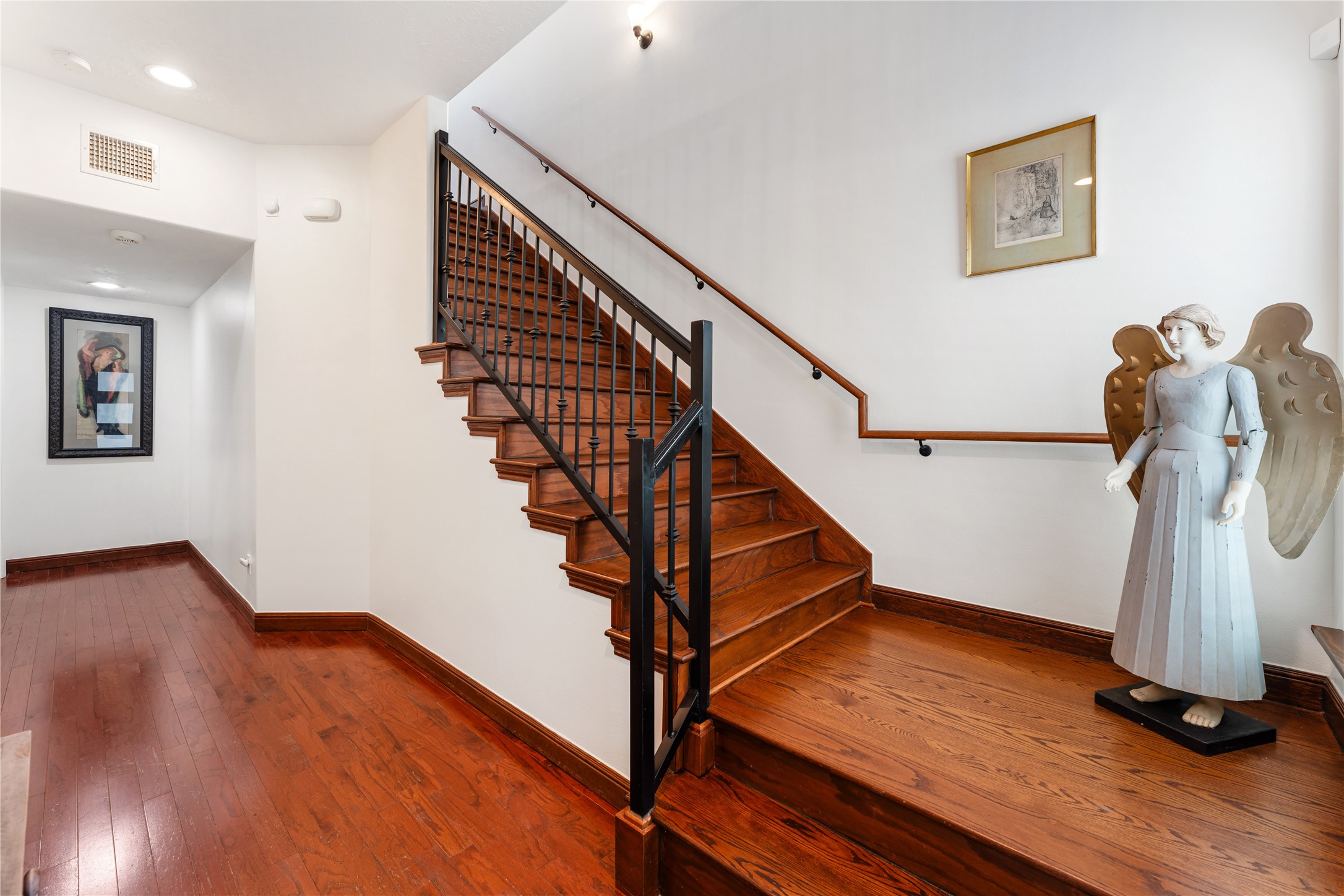 415 West 8th Street Houston, TX 77007 - Photo 6 of 39 Rich hardwood flooring and a beautifully crafted staircase create a striking architectural centerpiece from the moment you enter. Clean lines, soaring ceilings, and timeless finishes establish an atmosphere of understated luxury. Thoughtfully designed, this elegant transition seamlessly connects the home's open and inviting living spaces.