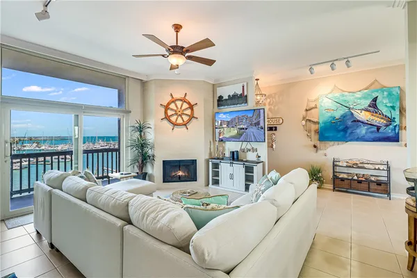 a living room with furniture kitchen view and a potted plant