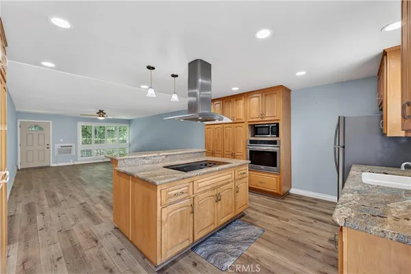 a kitchen that has a stove and a wooden floor