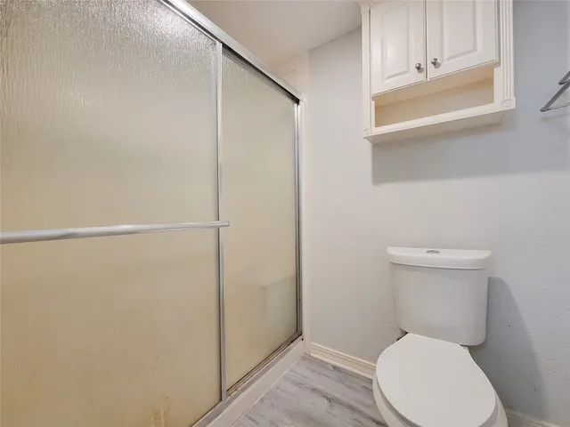 an empty room with a chandelier fan and windows