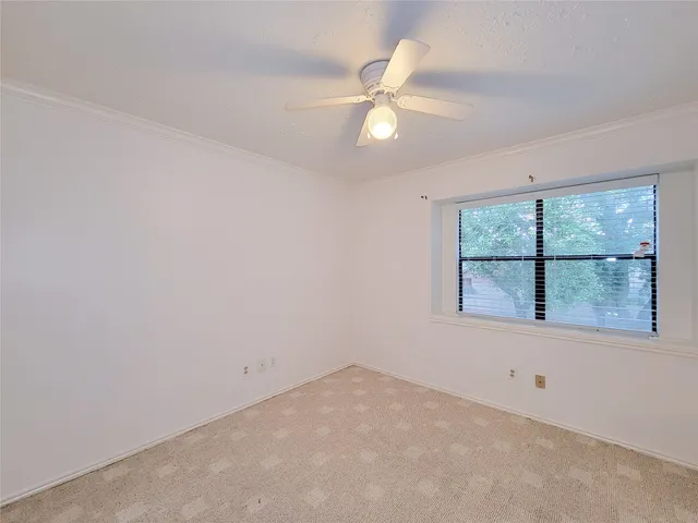 an empty room with a window and a fan