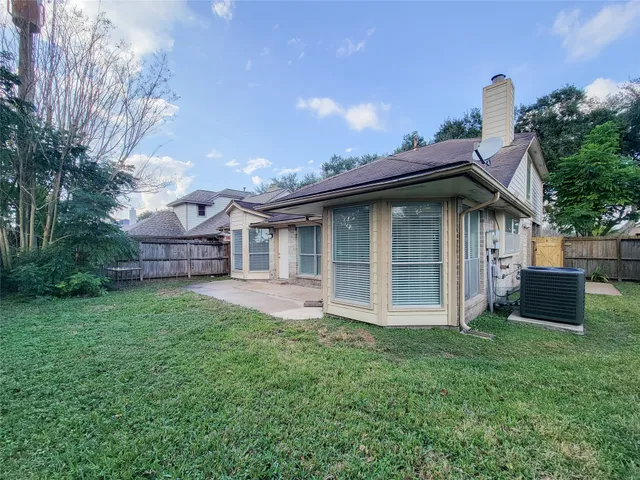 a view of a small house with wooden fence