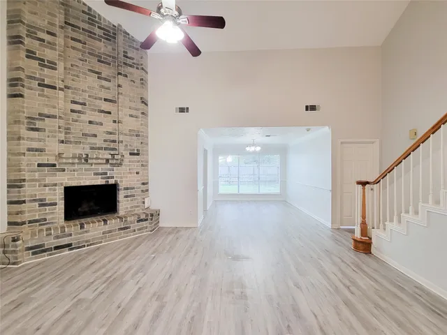 a view of an empty room with a fireplace and a window