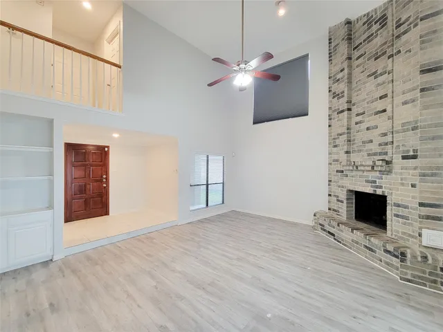 a view of empty room with wooden floor fireplace and stairs