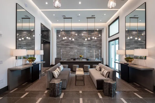 a living room with furniture large windows and a fireplace