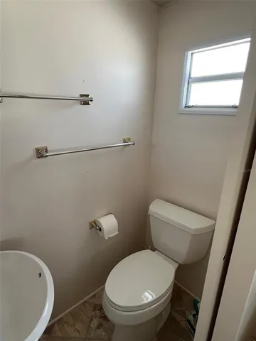a white toilet sitting next to a bath tub