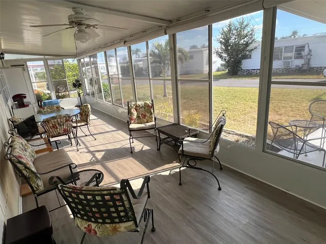 a living room with furniture and floor to ceiling windows