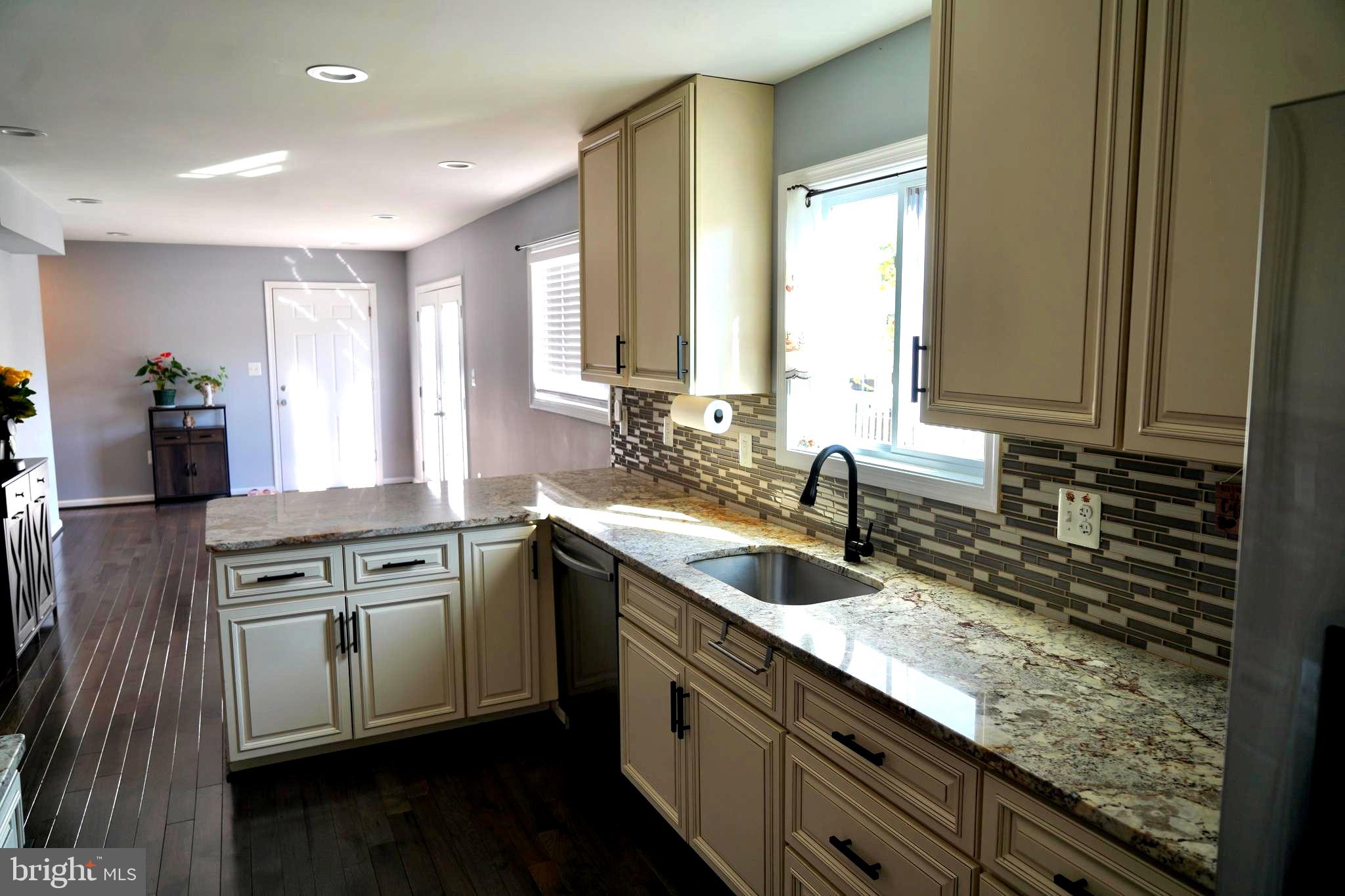 811 223rd Street Pasadena, MD 21122 - Photo 9 of 31 a kitchen with stainless steel appliances granite countertop a sink stove and cabinets