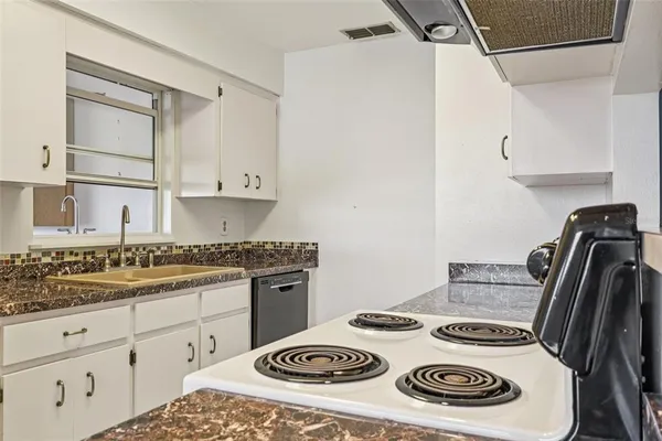 a kitchen with a stove and white cabinets