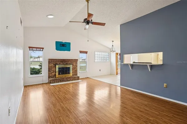 a view of a livingroom with wooden floor a fireplace and window