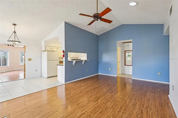 a view of a kitchen with wooden floor and a ceiling fan
