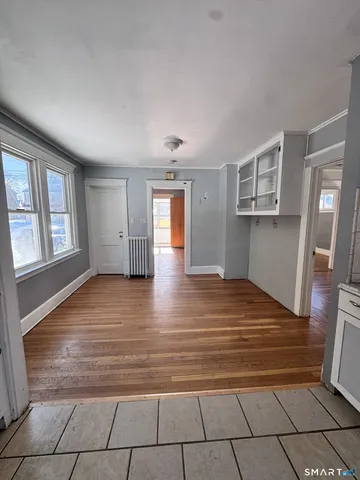 a view of empty room with window and wooden floor