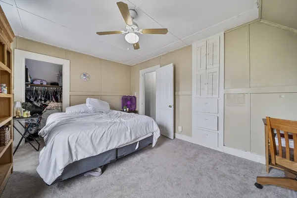 a spacious bedroom with a bed and a chandelier