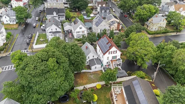 an aerial view of residential houses with outdoor space and trees