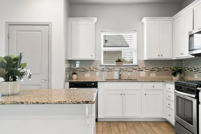 a kitchen with granite countertop white cabinets and white appliances