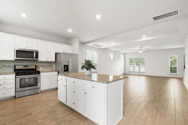 a kitchen with stainless steel appliances a refrigerator sink and microwave