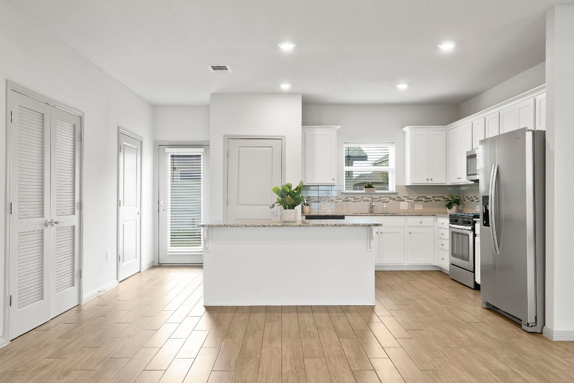 5913 B Charles Merle Dr., Unit 16 Austin, TX 78747 - Photo 6 of 35 a kitchen with stainless steel appliances granite countertop a refrigerator sink and white cabinets