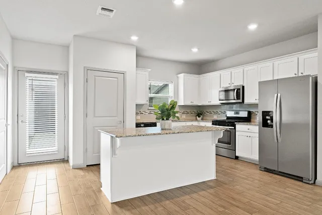a kitchen with a refrigerator a stove top oven and a center island