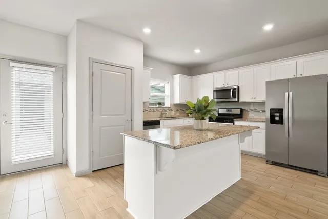a kitchen with kitchen island a sink a counter top space stainless steel appliances and cabinets