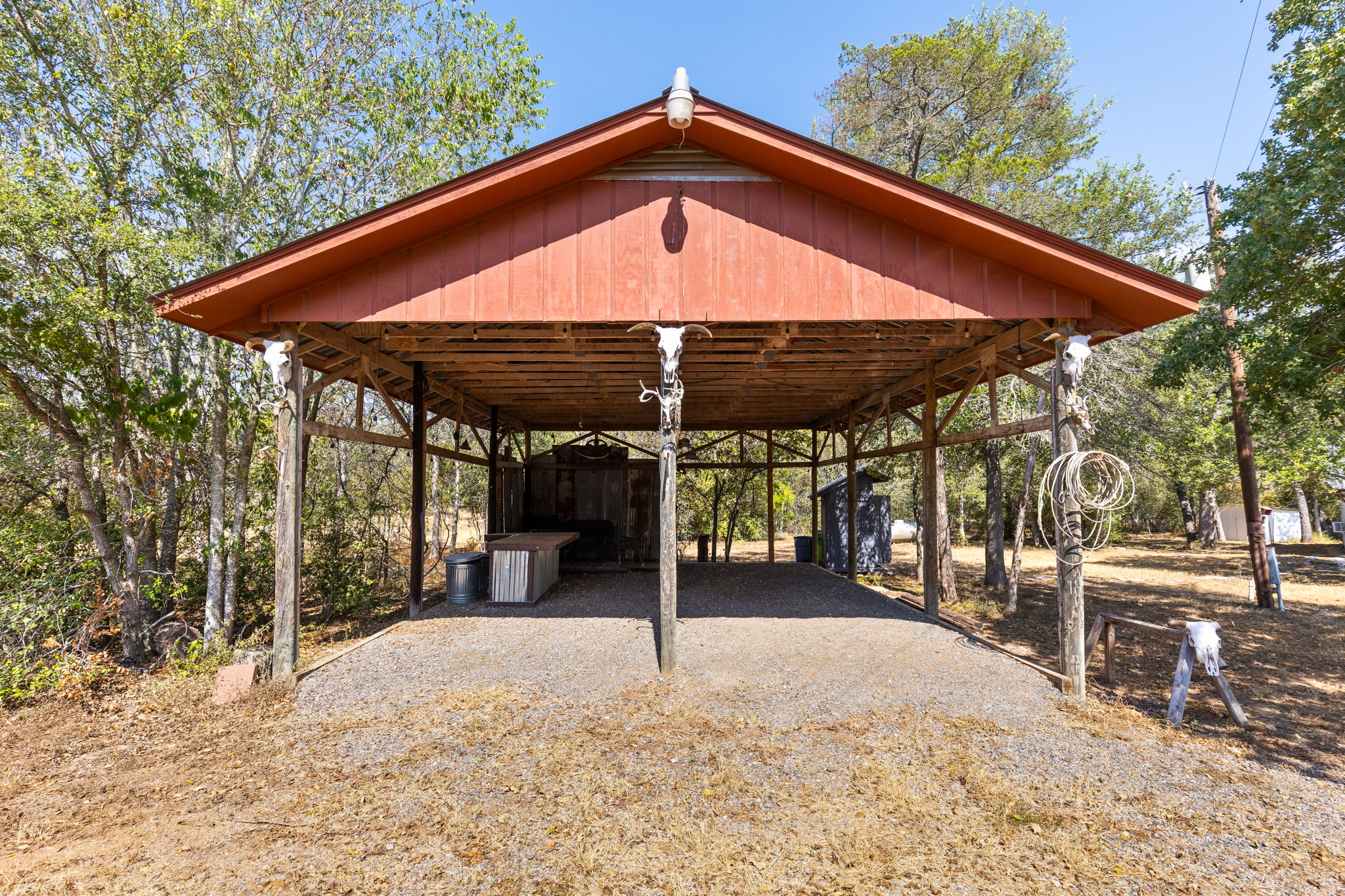 196 Willy Road Bastrop, TX 78602 - Photo 22 of 40 An open-sided timber pavilion provides covered outdoor space amidst mature trees.