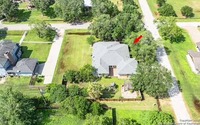 an aerial view of a house with a yard and a fountain