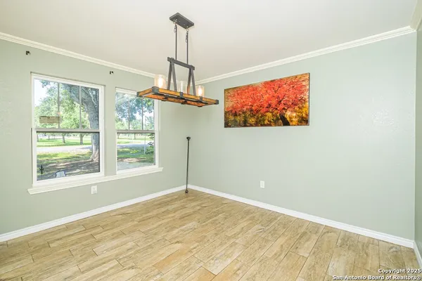 a view of a livingroom with a chandelier fan and windows