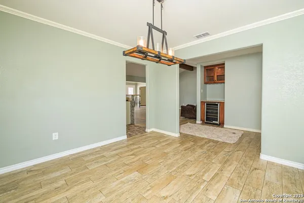 a view of an empty room with window and wooden floor