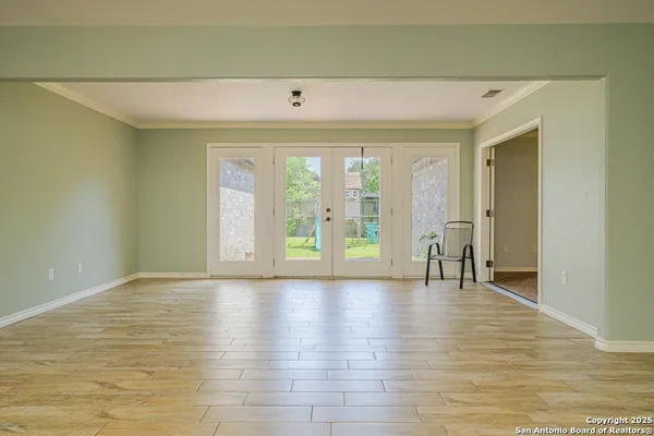 an empty room with wooden floor and a bathroom view
