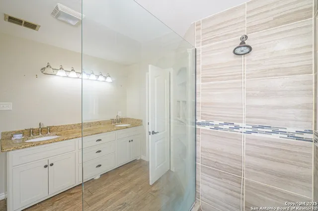 a bathroom with a granite countertop sink and white cabinets