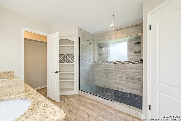 a bathroom with a granite countertop sink a vanity and shower