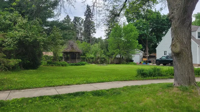 a front view of a house with a yard and tree