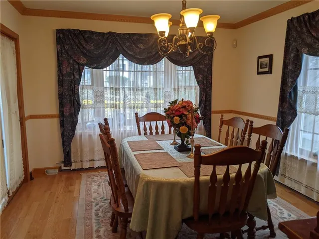 a view of a dining room with furniture a chandelier and wooden floor