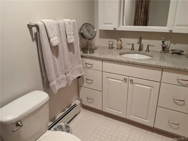 a bathroom with a granite countertop toilet sink and mirror