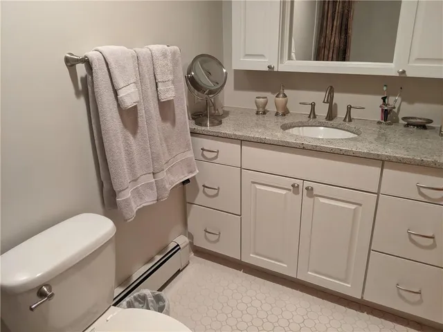 a bathroom with a granite countertop toilet sink and mirror