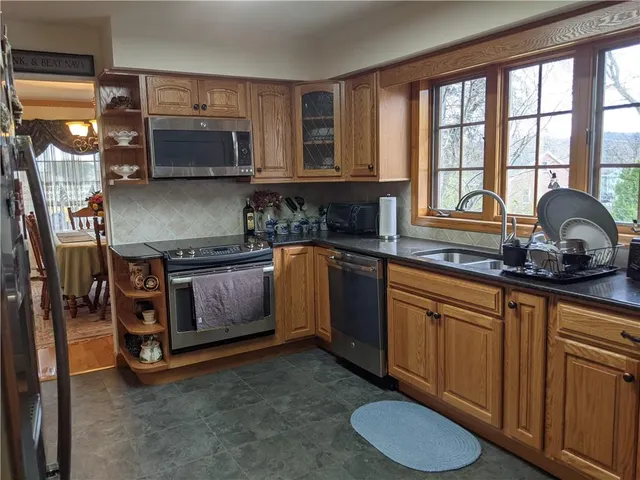 a kitchen with stainless steel appliances granite countertop a stove a sink and a microwave