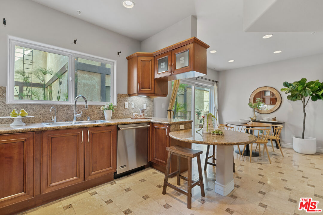 1747 South Barrington Avenue, Unit 103 Los Angeles, CA 90025 - Photo 11 of 45 a kitchen with a table chairs and a sink