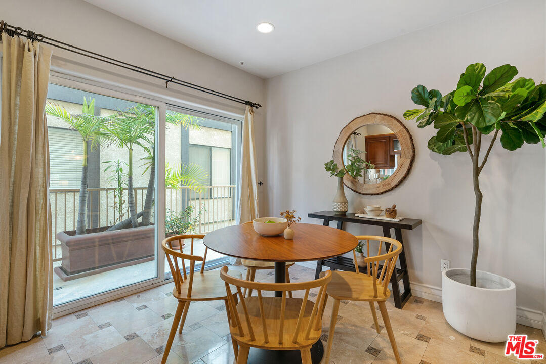 1747 South Barrington Avenue, Unit 103 Los Angeles, CA 90025 - Photo 12 of 45 a dining room with furniture potted plants and a table