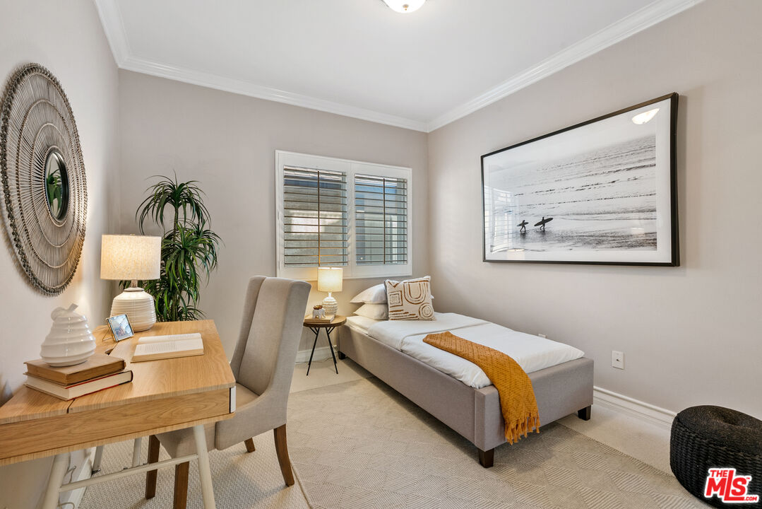1747 South Barrington Avenue, Unit 103 Los Angeles, CA 90025 - Photo 19 of 45 a bedroom with a bed a dresser and paintings on the wall