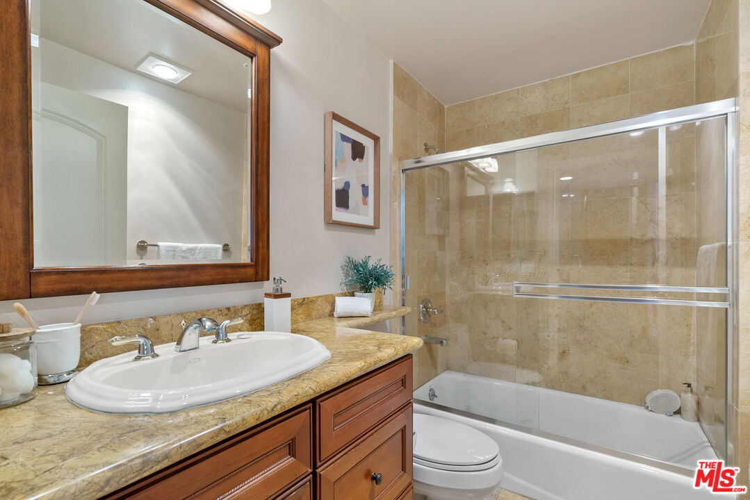 1747 South Barrington Avenue, Unit 103 Los Angeles, CA 90025 - Photo 20 of 45 a bathroom with a granite countertop sink toilet and shower