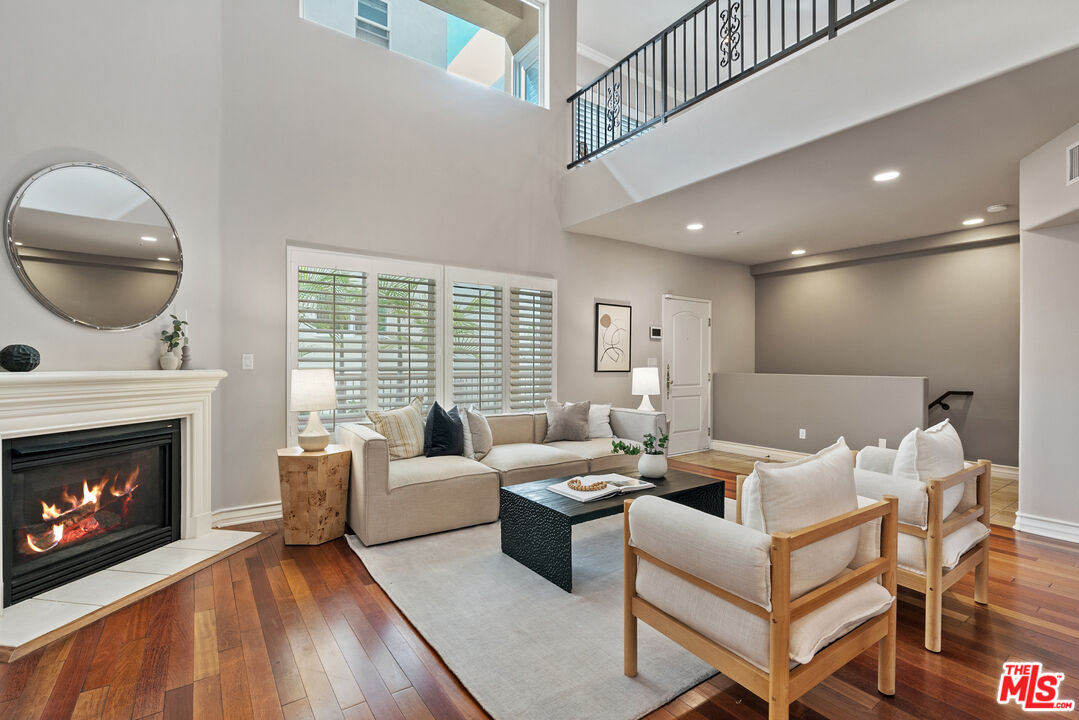 1747 South Barrington Avenue, Unit 103 Los Angeles, CA 90025 - Photo 2 of 45 a living room with furniture a fireplace and a large window