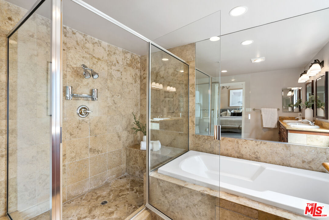 1747 South Barrington Avenue, Unit 103 Los Angeles, CA 90025 - Photo 27 of 45 a bathroom with a granite countertop bathtub shower sink and mirror