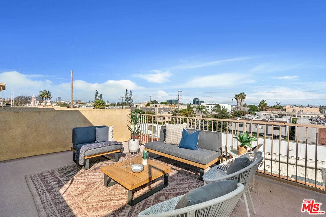 1747 South Barrington Avenue, Unit 103 Los Angeles, CA 90025 - Photo 34 of 45 a roof deck with couple of chairs and a floor to ceiling window