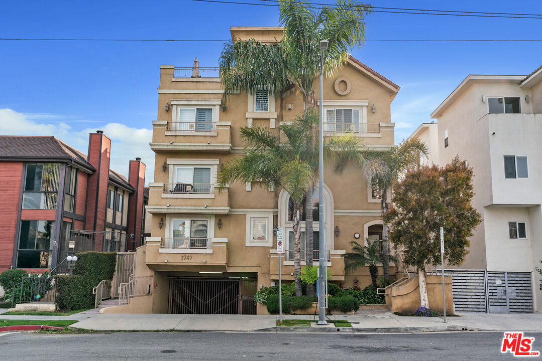 1747 South Barrington Avenue, Unit 103 Los Angeles, CA 90025 - Photo 36 of 45 a front view of a residential apartment building with a yard