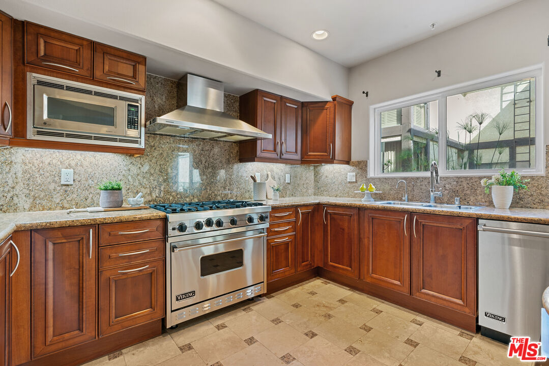 1747 South Barrington Avenue, Unit 103 Los Angeles, CA 90025 - Photo 8 of 45 a kitchen with stainless steel appliances granite countertop a stove sink and cabinets