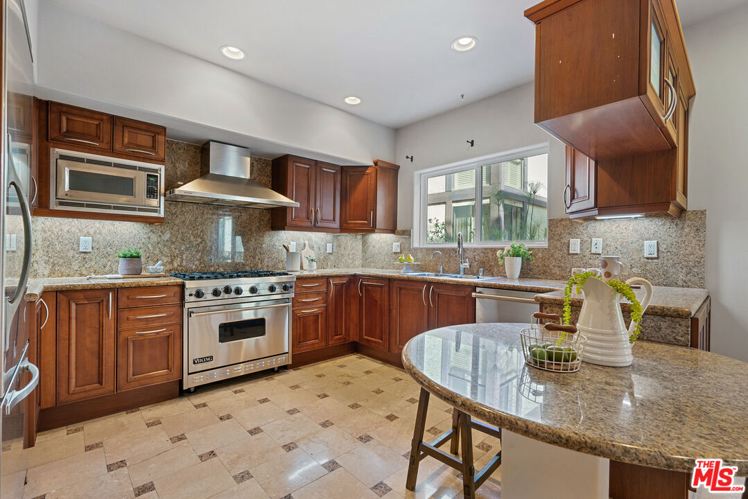 1747 South Barrington Avenue, Unit 103 Los Angeles, CA 90025 - Photo 9 of 45 a kitchen with stainless steel appliances granite countertop a sink stove and granite counter tops